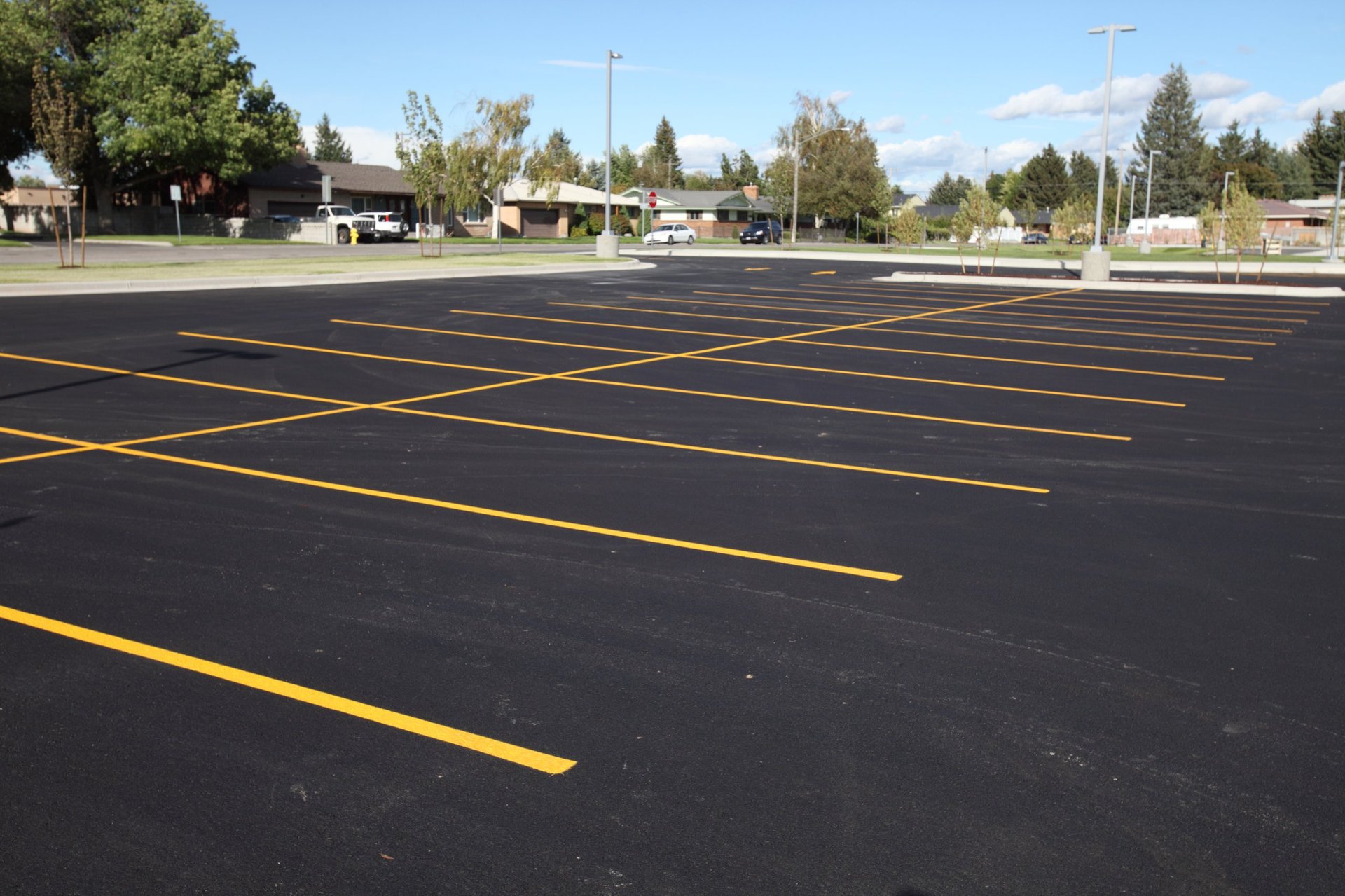 Fresh parking lot striping with bright yellow lines marking parking spaces in Austin, TX