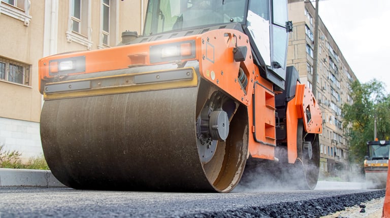 Modern asphalt roller compacting freshly laid pavement