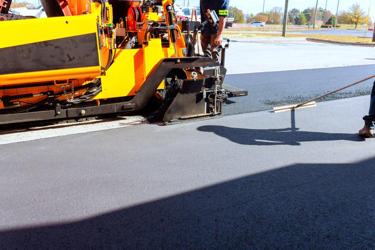 Workers use asphalt paving machines to lay new asphalt on parking lot in Central Texas — commercial parking lot paving by Austin Premier Paving serving Leander and Austin